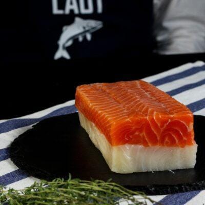 smoked salmon bali – red and white smoked fish roll sliced on board