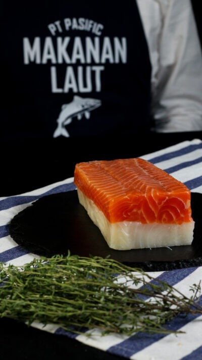 smoked salmon bali – red and white smoked fish roll sliced on board