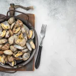 clams bali – steamed clams in rustic pan, top view