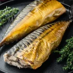 Smoked mackerel Bali — smoked mackerel with thyme on a black plate