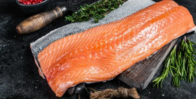 fresh salmon fillet bali – raw salmon fillet with herbs on dark background