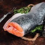 salmon bali – raw salmon cut in wooden tray with thyme