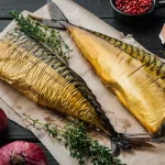 Smoked mackerel Bali — whole smoked mackerel with fresh herbs on parchment paper