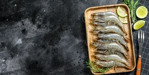 tiger prawn bali – whole raw tiger prawns on wooden tray with lime