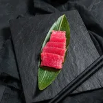 Tuna sashimi Bali — fresh tuna saku slices served with chopsticks and soy sauce
