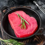 tuna steak bali – raw tuna steak with rosemary in cast iron pan